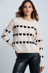 Lisa Todd Love Tracks Sweater in Sheepskin with black intarsia hearts.  Cotton/cashmere pullover crew neck sweater.  Long sleeves with dropped shoulders.  Intarsia hearts in front and sleeves.  Plain back.  Blanket stitch trim at cuffs. Rib trim at neck hem and cuff.  Classic fit._t_61429884551534