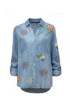 Kyla Seo Lil Shirt in Denim.  Pointed collar button down high low hem shirt.  Long sleeves with button cuff and button tab.  Back yoke.  Embroidered suns and stars. Slightly oversized, relaxed fit._t_60951618093422