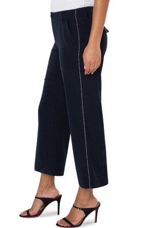 Liverpool Cargo Crop with Chain Trim in Lunar Blue a dark navy. Wide leg crop pant with button and zip closure. 2 large front pockets with stitch detail. 2 back flap cargo pockets. 26" inseam._34626792685768