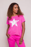 Suzy D Star High Low Tee in Fuschia. Crew neck short sleeve high low hem tee with large screen printed distressed white star on front. Inverted U-shaped hem in front; U-shaped back. Angled seams to front. Relaxed fit._t_34224822943944