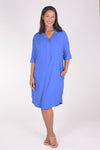 Perlavera Dina Dress in Blue.  Below the knee popover dress with pointed spread collar, hidden button placket and short cuffed sleeves.  Curved high low hem. In seam pockets.  One size fits most._t_34324036092104