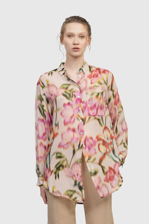 Alembika Floral Oversized Blouse.  Pink and green abstract watercolor floral print on pale pink.  Pointed collar button down shirt in translucent fabric.  Long sleeves with button cuffs.  Back yoke.  Shirt tail hem.  Relaxed fit._34779979677896