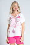 APNY Short Sleeve Embroidered Top in White with pink embroidery on front and placket.  Crew neck with split v and tassel tie.  Short sleeves.  Straight hem. Relaxed fit._t_35228885811400