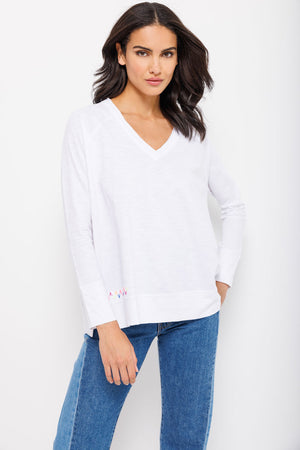 Lisa Todd Beach Tee in White. V neck tee with raglan long sleeve. Banded cuff. Banded hem with side slits. Multi colored hand stitch detail in front. Relaxed fit._35222810722504