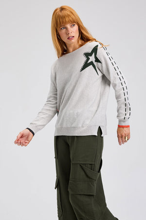 Zaket & Plover Threaded Star Sweater in Marled gray.  Boatneck dolman long sleeve knit.  2 intarsia and embroidered stars on front.  Contrast color threaded double rows of stitching down each sleeve.  Plain back.  Rib trim at neck and cuff.  Side slits.  Relaxed fit._61395591037294