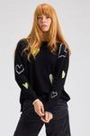 Zaket & Plover Intarsia Heart Sweater in Black.  Boat neck long sleeved. sweater with multi-color, multi-sized intarsia hearts on front and sleeves.  Plain back.  Rib trim at cuff and hem.  Contrast color trim at cuff.  Side slits. Relaxed fit._t_61457766908270