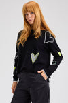 Zaket & Plover Intarsia Heart Sweater in Black.  Boat neck long sleeved. sweater with multi-color, multi-sized intarsia hearts on front and sleeves.  Plain back.  Rib trim at cuff and hem.  Contrast color trim at cuff.  Side slits. Relaxed fit._t_61457766941038