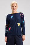 Zaket & Plover Intarsia Heart Sweater in Dark Denim.  Boat neck long sleeved. sweater with multi-color, multi-sized intarsia hearts on front and sleeves.  Plain back.  Rib trim at cuff and hem.  Contrast color trim at cuff.  Relaxed fit._t_61457767006574