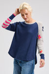 Zaket & Plover My Happy Sweater in Denim.  Solid denim front and back with striped colorblock right sleeve and gray left sleeve with multi intarsia flowers.  Solid rib trim at neck and cuff.  Curved high low hem.  Relaxed fit._t_61200732586350