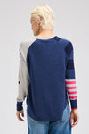 Zaket & Plover My Happy Sweater in Denim.  Solid denim front and back with striped colorblock right sleeve and gray left sleeve with multi intarsia flowers.  Solid rib trim at neck and cuff.  Curved high low hem.  Relaxed fit._t_61200732619118