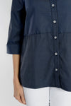 Cali Girls Boxy Half and Half Blouse in Navy/Black stripes. Convertible collar button down with 3/4 sleeve and split cuff. Subtle tone on tone print. Blouse is split in half at waist with print running bi-directionally. High low hem. Side slits.Relaxed fit._t_34092496421064