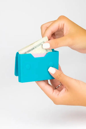Grab and go with this cute and quirky travel accessory! This silicone card case with a magnetic snap closure stores all your cards and bills with ease. Perfect for those quick errand runs or your next vacation!_33094036685000