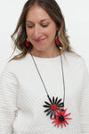 The Floral Statement Necklace is a wearable piece of art! This sculptural and unique necklace features two handcrafted wooden flowers in black and red with clusters of tiny beads in the centers in corresponding colors adding dimension to these artful pendants. _t_33973397455048