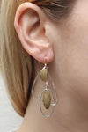 Large open silver colored organic shapes accented by golden geometric charms dangling from a standard wire earring fish hook._t_32610004435144