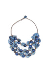 A stylish earth-friendly statement necklace featuring 3 strands of hand-carved beads in various shapes and sizes made from tagua nuts, bombona seeds, and acai berries on an suede cord with button and loop closure. _t_33405707780296